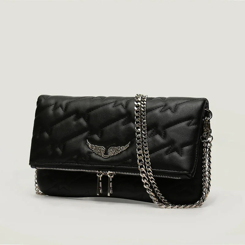 Black quilted leather handbag with silver chain strap and wing emblem on light background