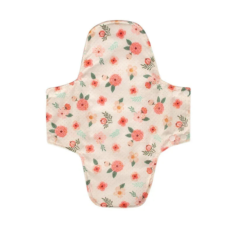 Reusable cloth menstrual pad with pink floral pattern and snap buttons on white background