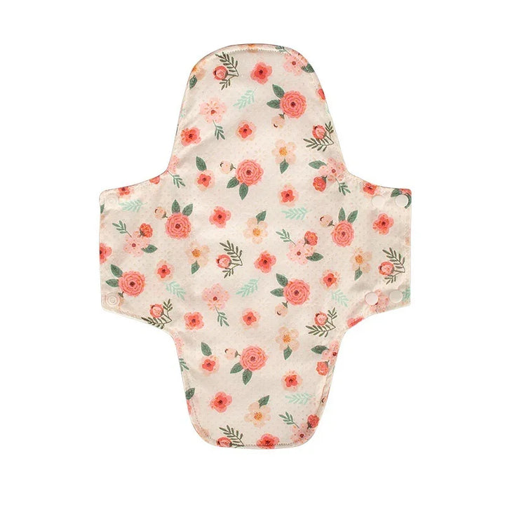 Reusable cloth menstrual pad with pink floral pattern and snap buttons on white background