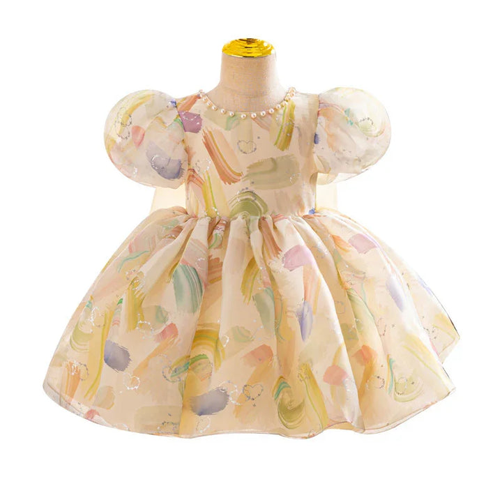 Pastel watercolor print baby girl dress with puff sleeves and pearl neckline on mannequin