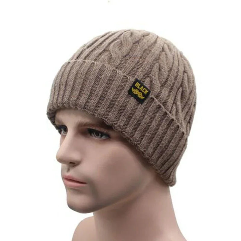 Beige knitted cable-pattern winter beanie with folded brim and black label on mannequin head