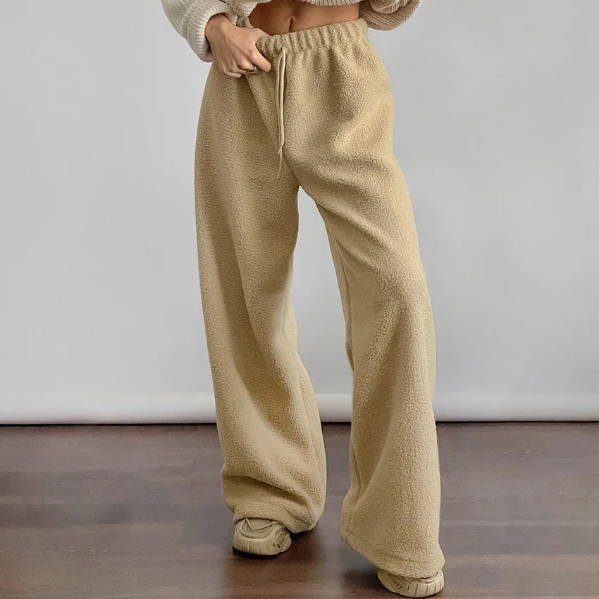 Person wearing beige sherpa fleece wide-leg pants with elastic waist and drawstring, standing indoors