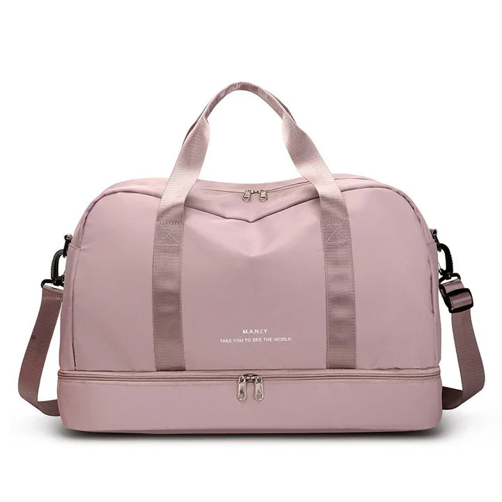 Light pink duffel bag with dual handles, shoulder strap, and lower zipper compartment