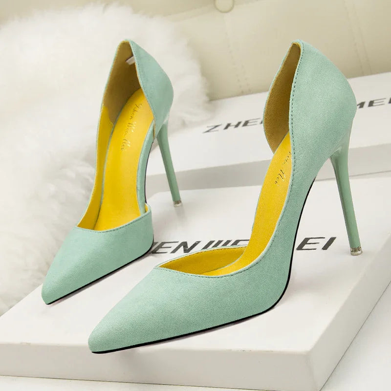 Pair of mint green high-heeled suede pumps with pointed toes on white branded boxes