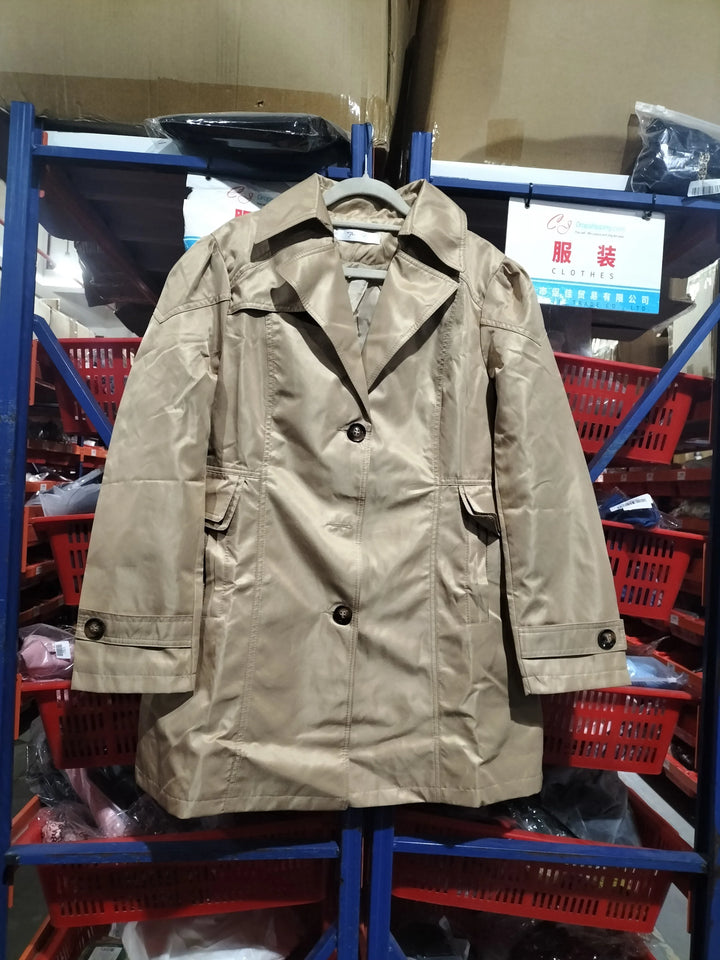 Beige trench coat hanging on a hanger in a warehouse with shelves and red baskets
