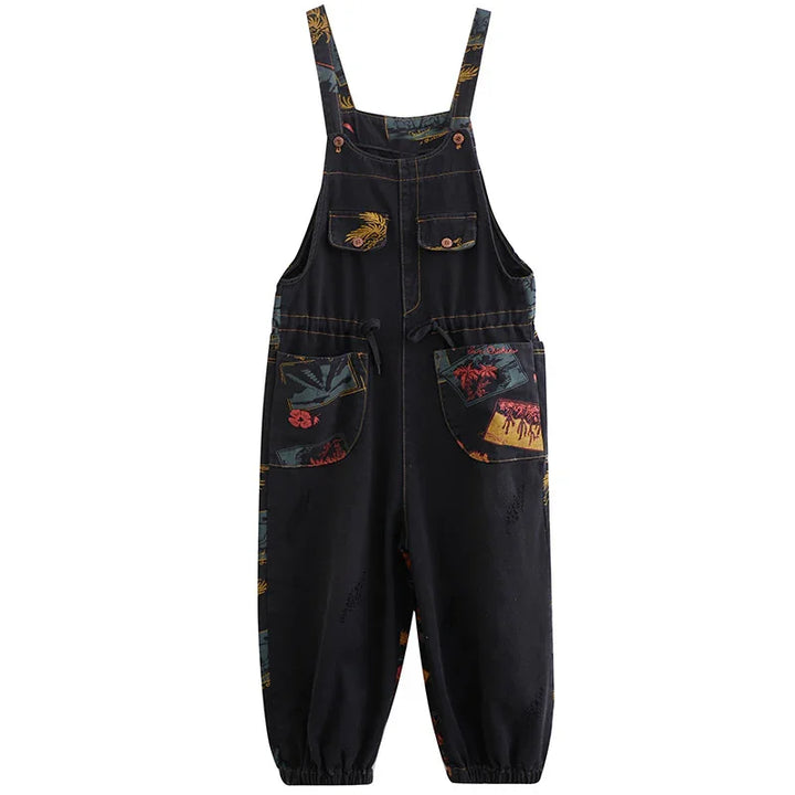 Black overalls with tropical floral and leaf print pockets and adjustable straps, elastic cuffs