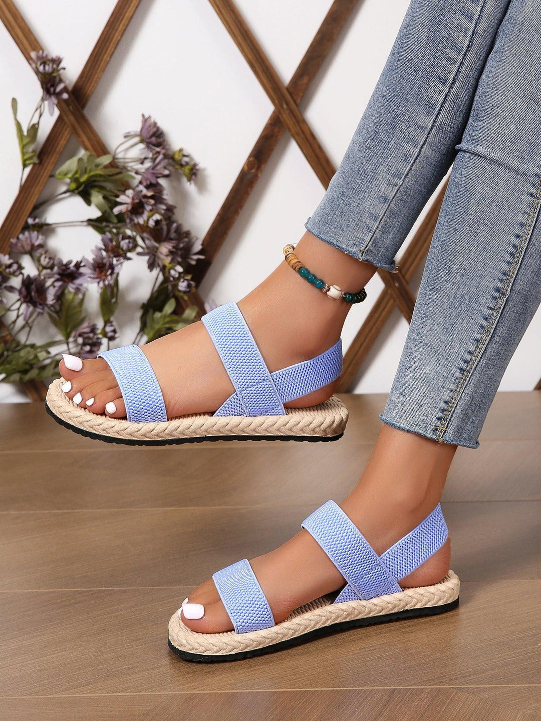 Light blue woven strap sandals with braided sole worn with skinny jeans and beaded ankle bracelet