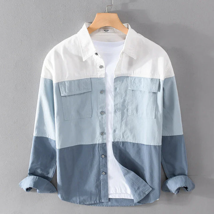 Men's casual button-up shirt with white, light blue, and dark blue color blocks hanging on hanger