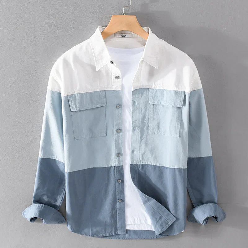 Men's casual button-up shirt with white, light blue, and dark blue color blocks on wooden hanger