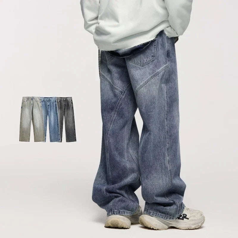 Person wearing loose, baggy faded blue denim jeans and white sneakers on plain background