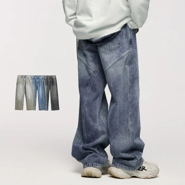 Person wearing loose, baggy faded blue denim jeans and white sneakers on plain background