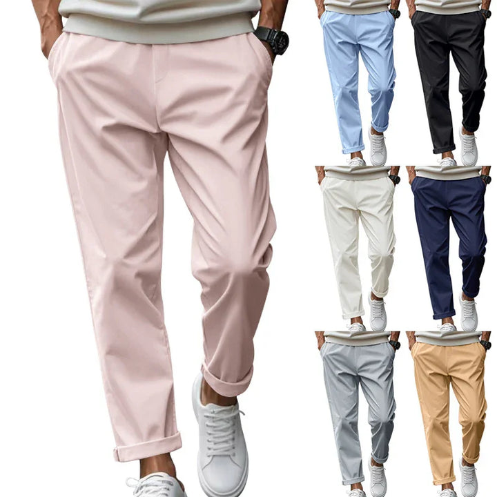 Men's casual slim-fit pants in pastel pink, light blue, black, beige, navy, white, and gray with rolled cuffs and white sneakers