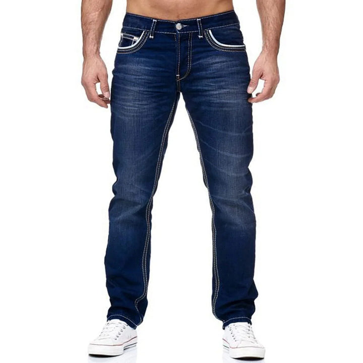 Men's slim fit dark blue denim jeans with white stitching and casual white sneakers