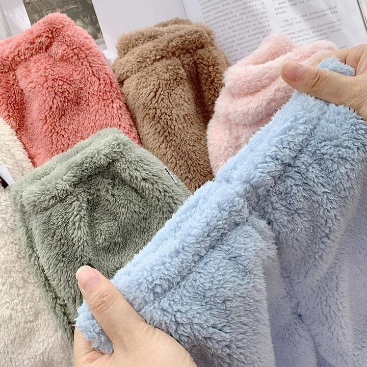 Soft fleece fabric in blue, green, pink, brown, coral, and beige colors held in hands, cozy textile samples
