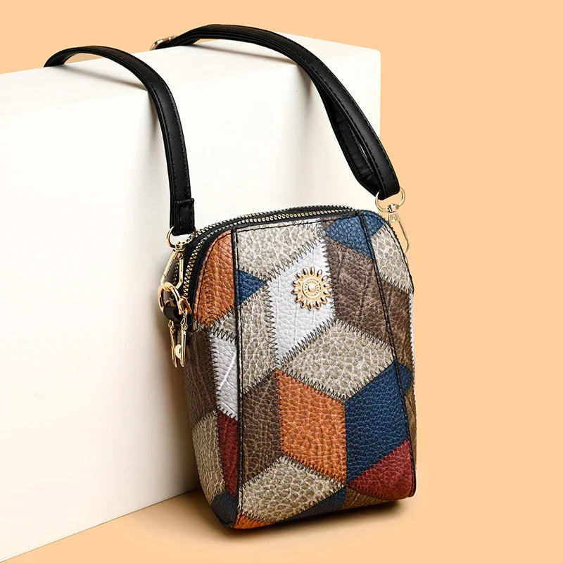 Small textured leather crossbody bag with multicolor geometric patchwork and black strap