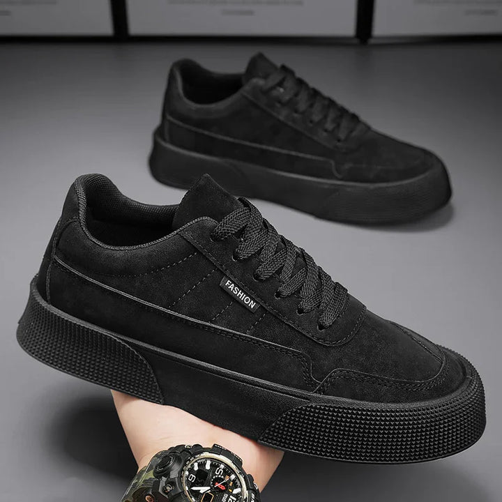 Pair of black casual fashion sneakers with textured soles and lace-up design