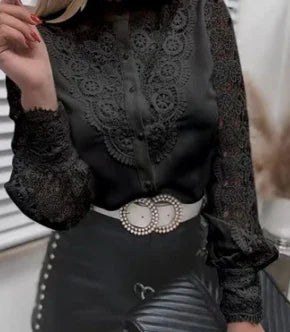 Elegant black lace blouse with intricate floral patterns, paired with a white belt and black quilted purse