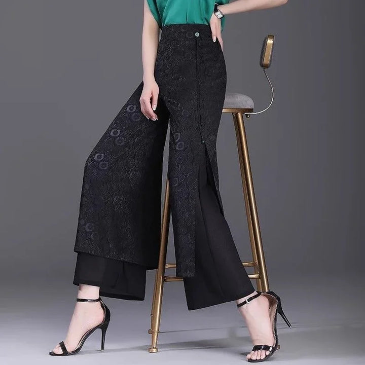 Woman wearing black floral lace overlay wide-leg pants with front slit and black high heel sandals