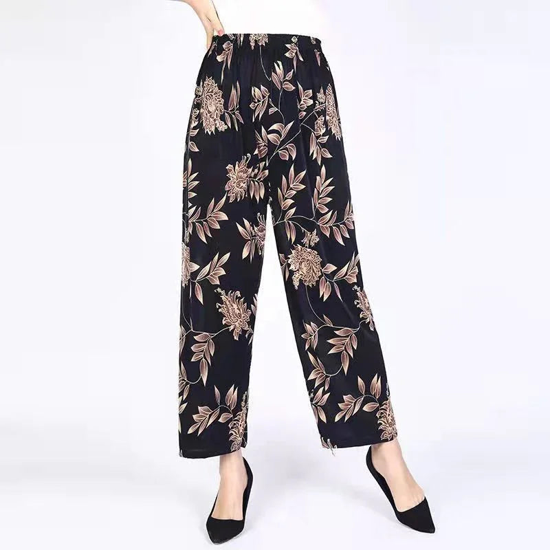 Black wide-leg pants with beige floral print, elastic waist, worn with black pointed shoes