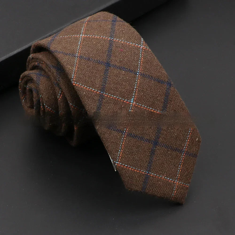 Rolled brown wool tie with navy and orange windowpane check pattern on black surface