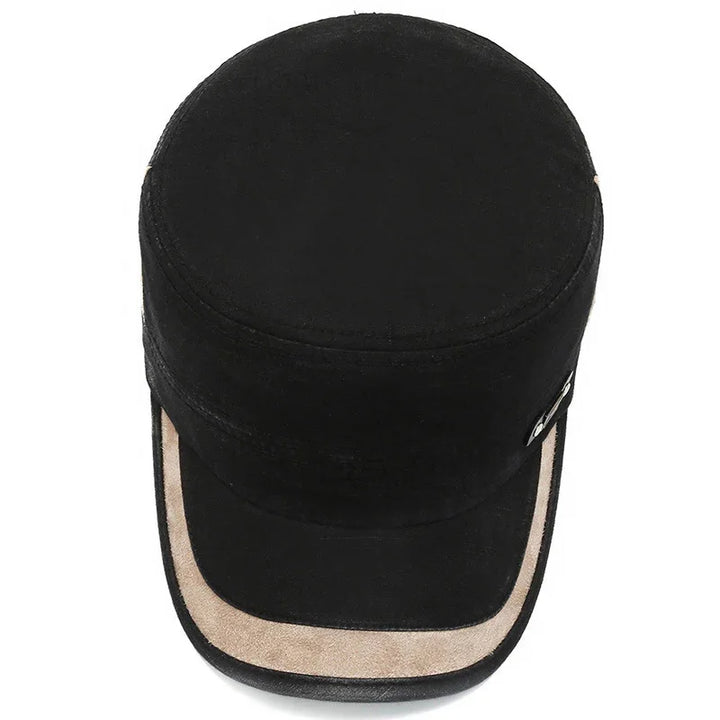 Black suede flat top cap with beige trim and buckle detail on side