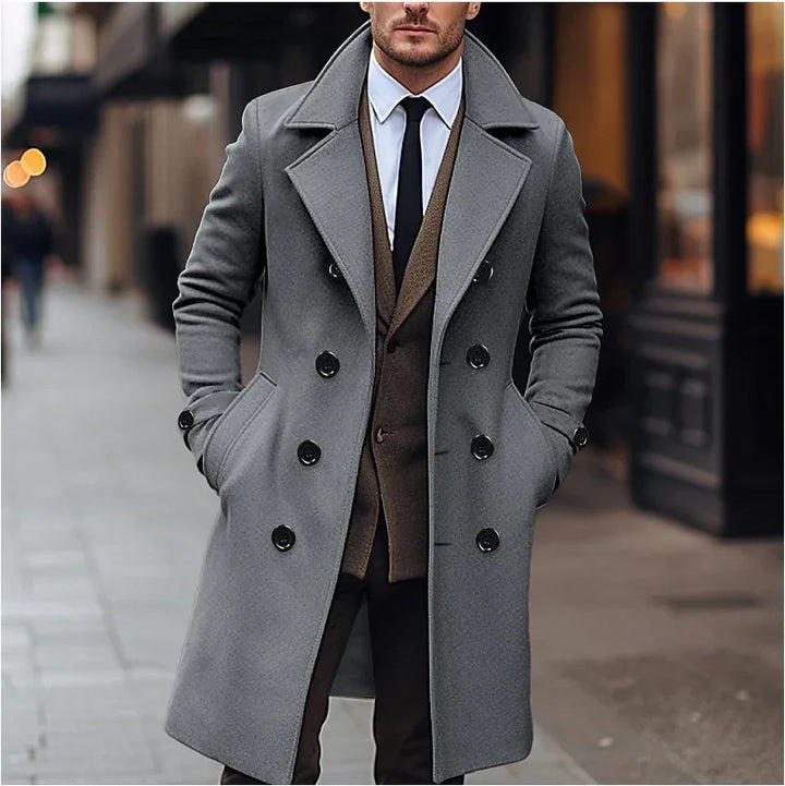 Man wearing stylish grey double-breasted wool coat over brown blazer and black tie on city street