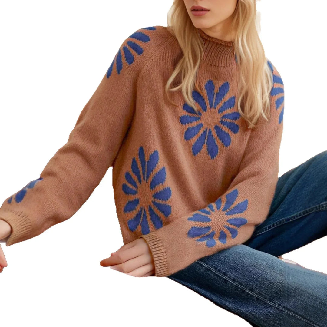 Woman wearing brown knit sweater with large blue flower patterns paired with denim jeans