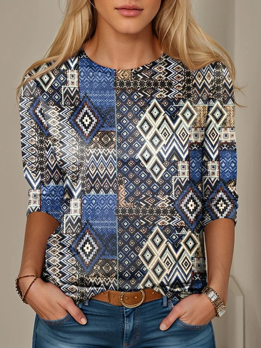 Woman wearing blue and beige geometric pattern long sleeve top with blue jeans and brown belt