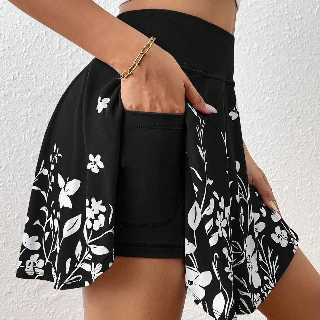 Black athletic skirt with white floral print and built-in shorts pocket hand near waist
