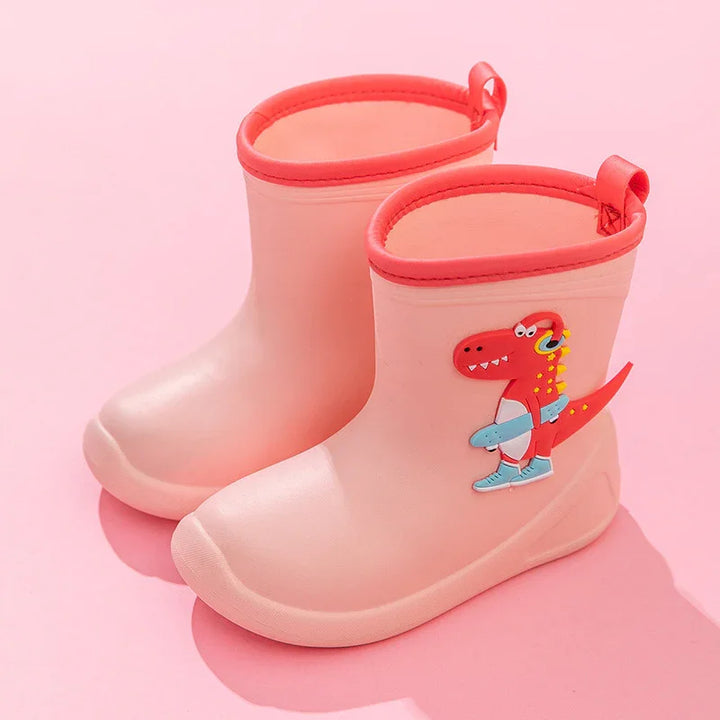 Pink children's rain boots with cartoon red dinosaur and skateboard design on a pink background
