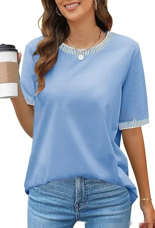 Woman wearing light blue casual T-shirt with striped trim and jeans holding coffee cup