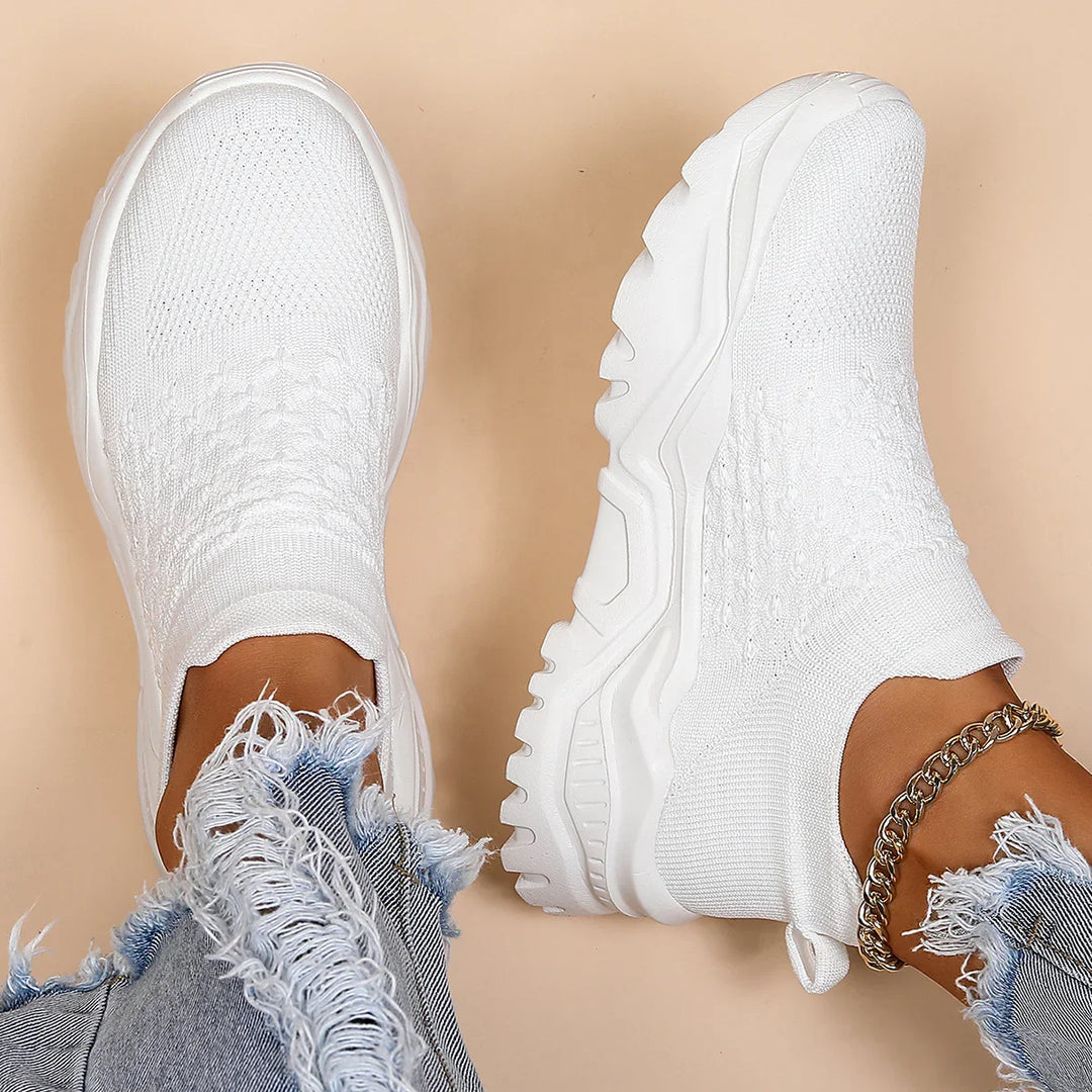 white knit slip-on sneakers with thick soles worn with distressed blue jeans and gold anklet