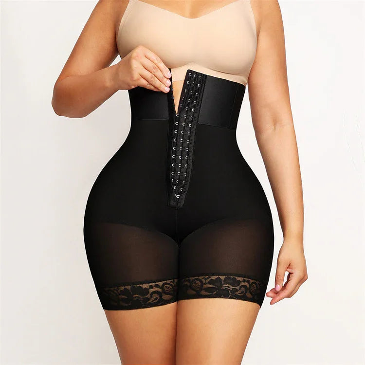 Woman wearing black high-waisted waist trainer shorts with lace trim and hook-and-eye front closure