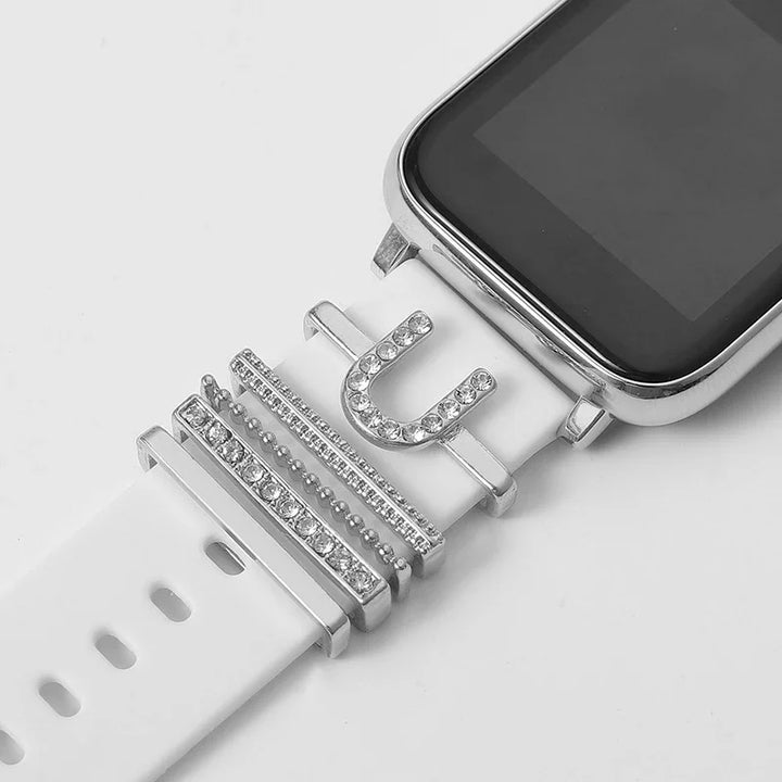white smartwatch band with silver rhinestone charms including horseshoe and bar designs on white background