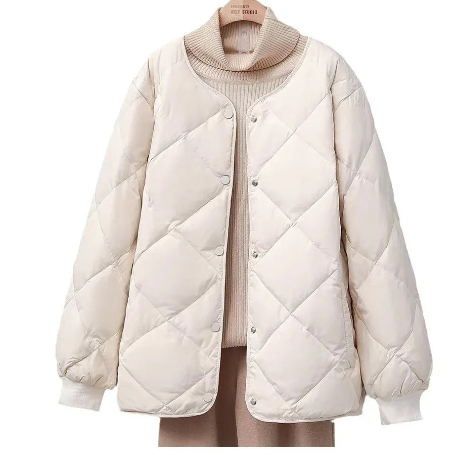 Beige quilted puffer jacket with snap buttons on a turtleneck sweater background