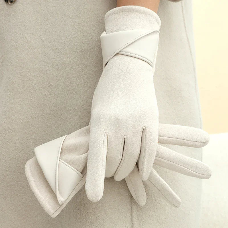 Elegant white winter gloves with leather trim worn on hands over a soft beige coat