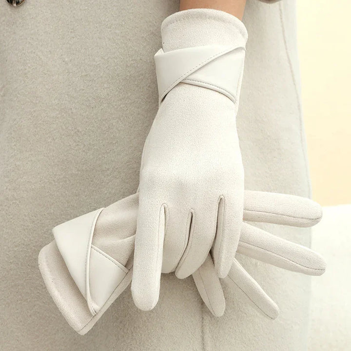 Elegant white winter gloves with leather trim worn on hands over a soft beige coat