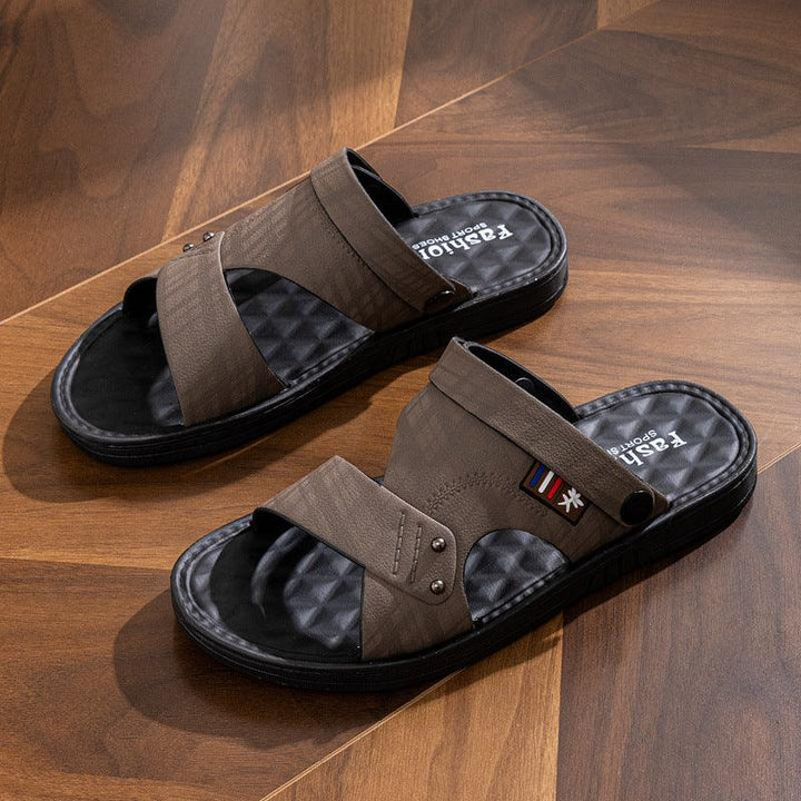 Brown sport sandals with black cushioned soles on wooden floor, featuring adjustable straps