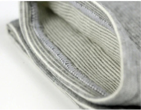 Close-up of folded grey ribbed fabric with stitched edge, soft material texture