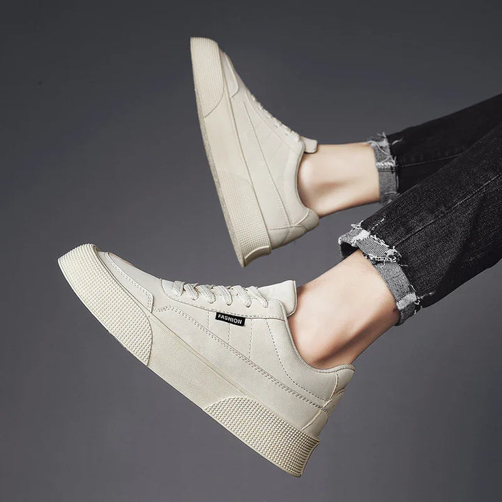 Pair of white casual platform sneakers with textured soles worn with black frayed hem jeans
