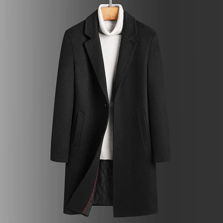 Black wool blend men's overcoat with notch lapel and side pockets over white turtleneck sweater