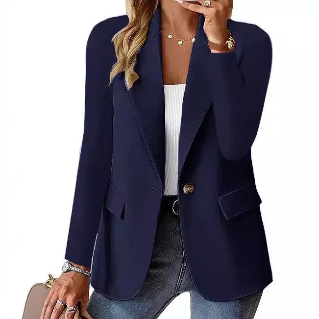 Woman wearing navy blue single-button blazer with notch lapels, white top, and jeans