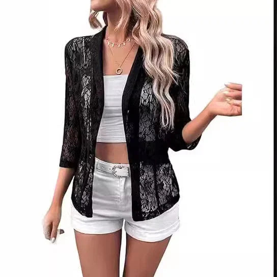 woman wearing black floral lace cardigan over white crop top and white shorts with belt
