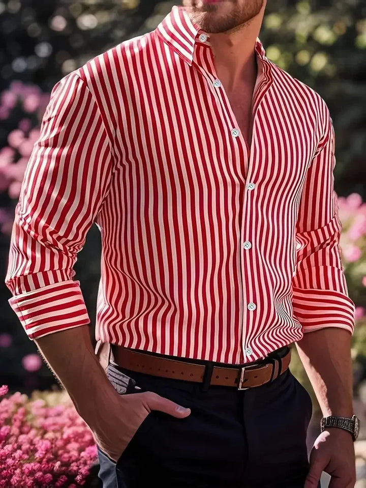 Man wearing red and white striped long-sleeve button-up shirt with brown belt and dark pants outdoors
