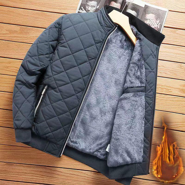Black quilted jacket with soft grey fur lining displayed on wooden surface with fire graphic
