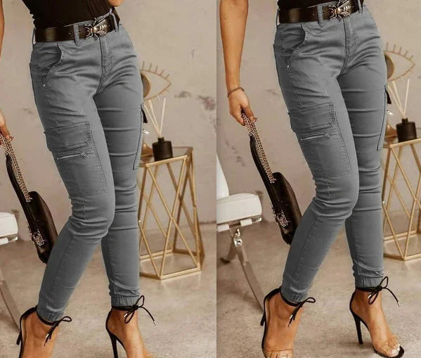 Gray slim-fit cargo pants with side pockets styled with black belt and high heels in a modern indoor setting