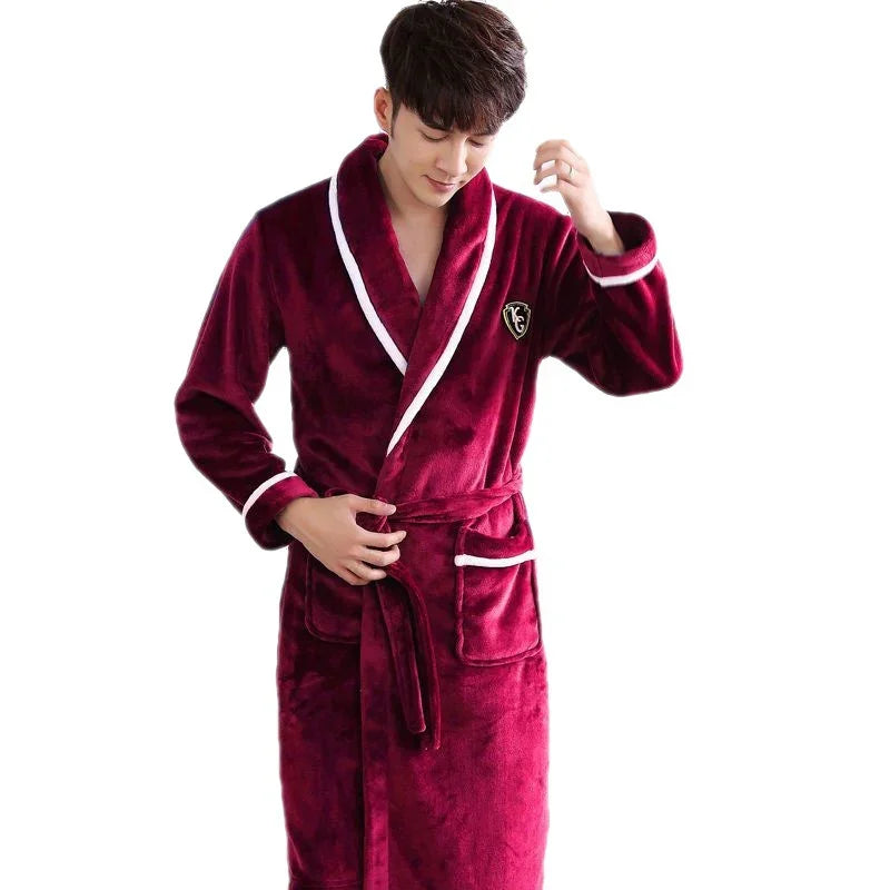 Man wearing a plush burgundy bathrobe with white trim and pockets, adjusting belt