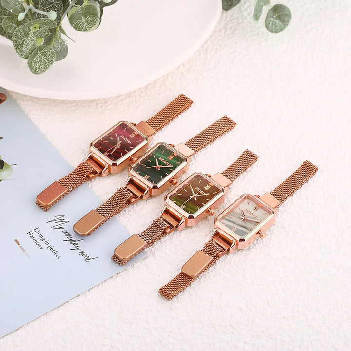 Four rose gold mesh band watches with square faces in red, green, yellow, and white on textured surface