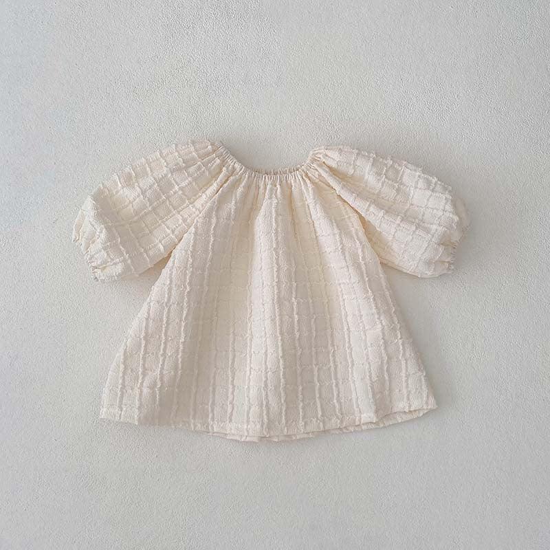 Cream textured baby dress with puff sleeves on white background