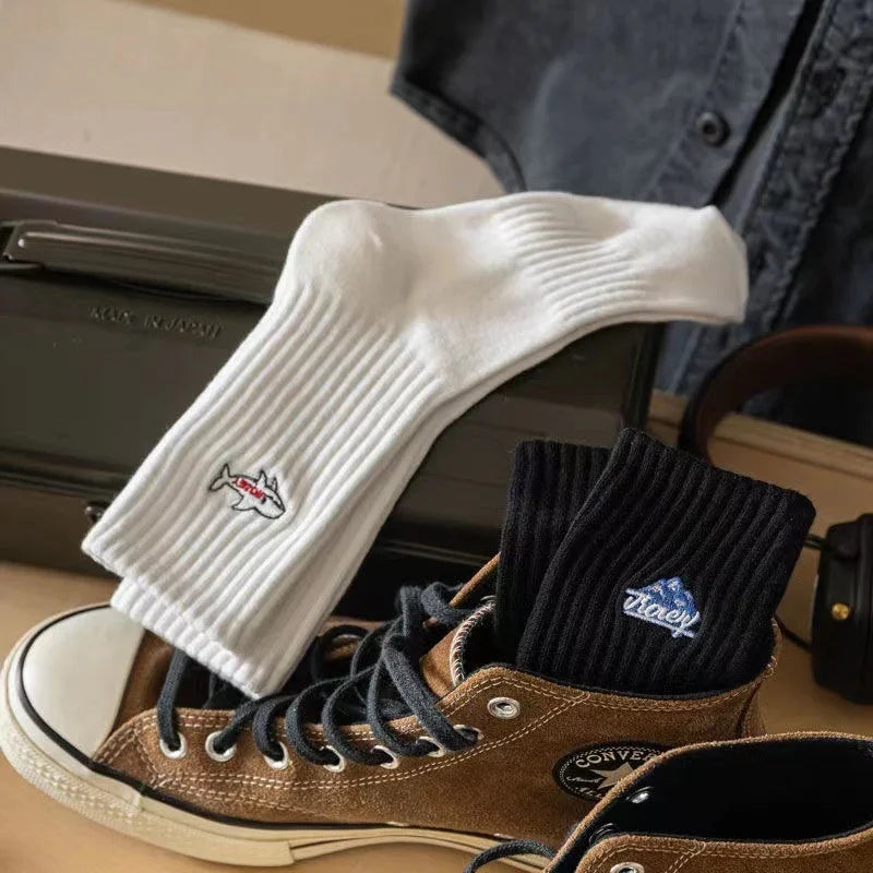 Brown Converse high-top sneakers with black and white ribbed socks featuring shark and ice cream logos